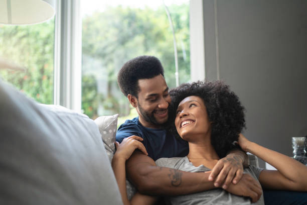 African couple lying down and having romantic moment on couch
