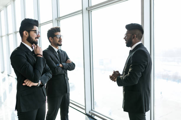 istock Three asian corporate executives standing in front of windows discussing business 1146565143