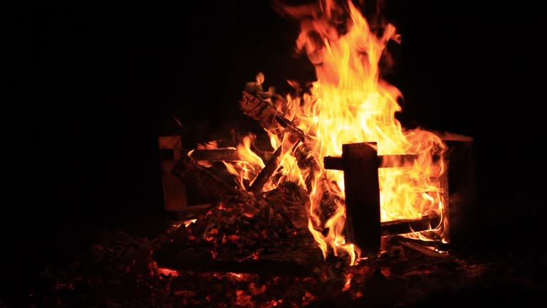 No Home style footage. Sound. Close-up video of sound. Exteme close-up video of a burning picnic table at the end of a party by a body of water. Summer holidays fun or malicious destruction or property in a bushfire. Raging flames, intense heat and smoke.