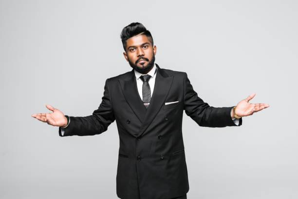 istock Portrait, dumb clueless young indian man, arms out asking why what's the problem who cares so what, I don't know. Isolated white background. 1146570526