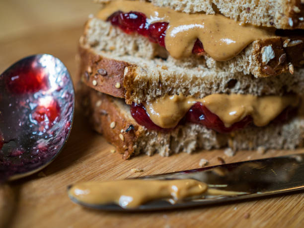 istock Peanut Butter and Jelly Sandwich, Spoon and Knife on Cutting Board 1146571768