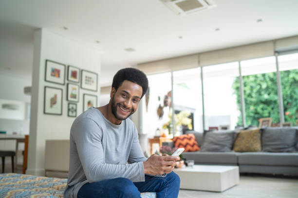 istock Young man using cellphone in the living room 1146572841