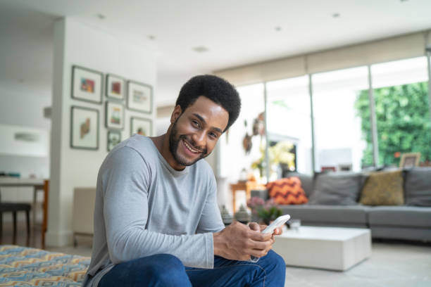 istock Young man using cellphone in the living room 1146572842