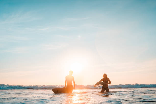 Couple returning after a long day surfing. stock photo