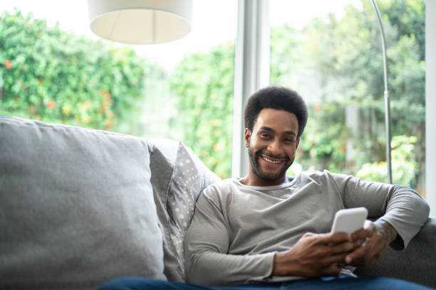 istock Young man using cellphone in the living room 1146574228