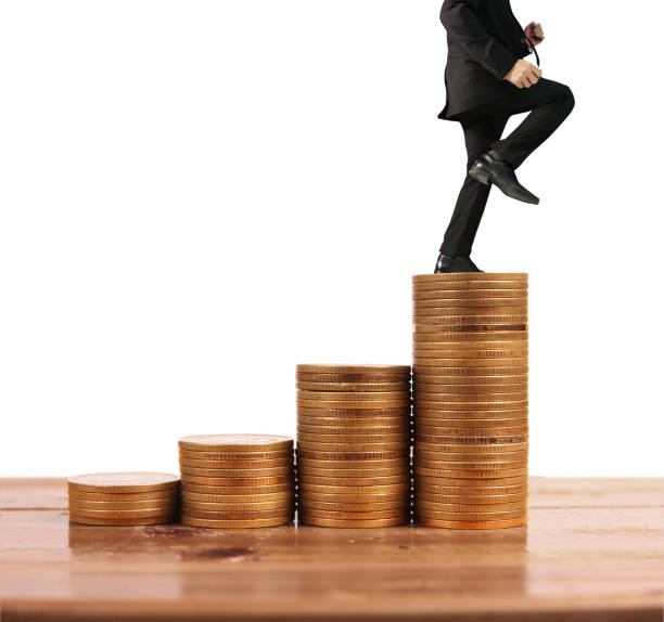 istock Businessman walk on stack of coins which grows success 1146584280