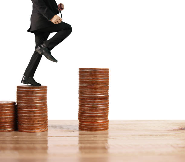 istock Businessman walk on stack of coins which grows success 1146584285