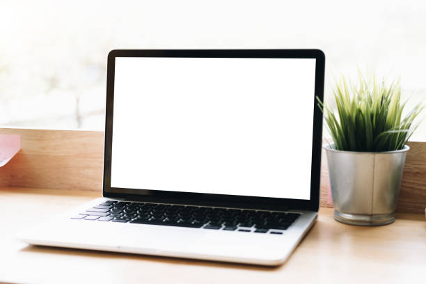 istock Mockup blank screen laptop on desk in office room background. 1146584477