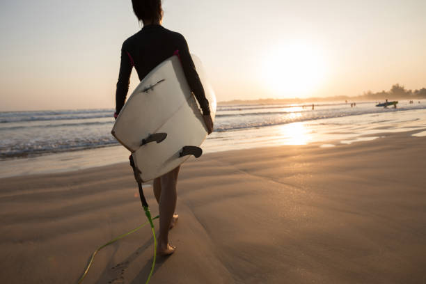 istock Woman surfer with surfboard ready to surf on a beach 1146588863