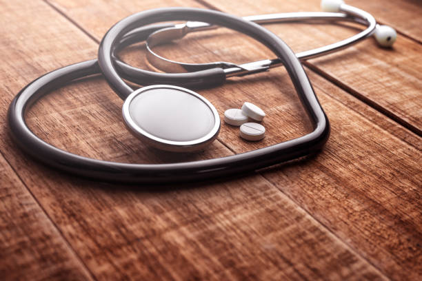 Stethoscope heart shaped and pills on wooden background. Medical heart concept, cardiology. The idea of medical care for heart disease. Stethoscope heart shaped and pills on wooden background banner. Heart concept, cardiology. The idea of medical care for heart disease. blood pressure medication stock pictures, royalty-free photos & images