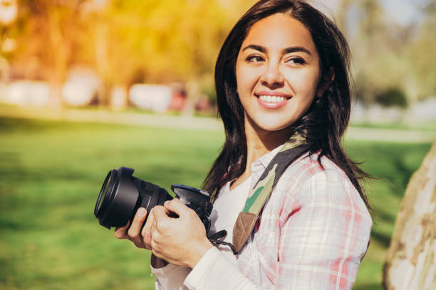 istock Cheerful smiling young photographer posing with camera 1146589880