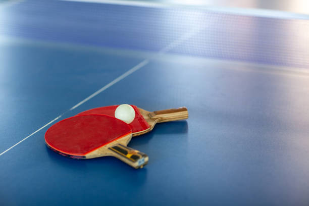 istock pingpong rackets and ball and net on a blue pingpong table 1146591098