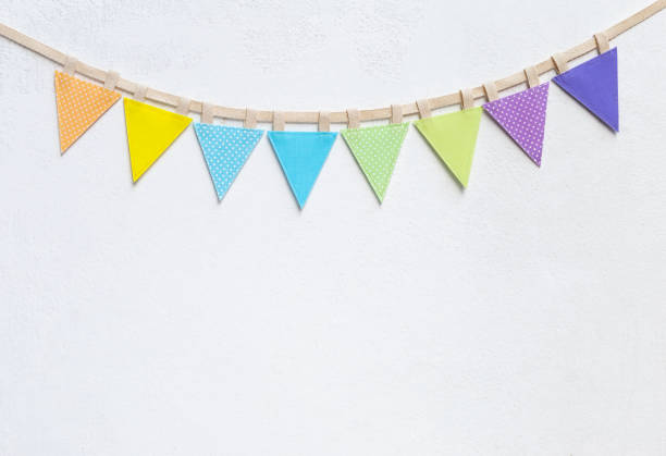 istock Colorful vintage fabric party flag on white cement wall texture background 1146595611