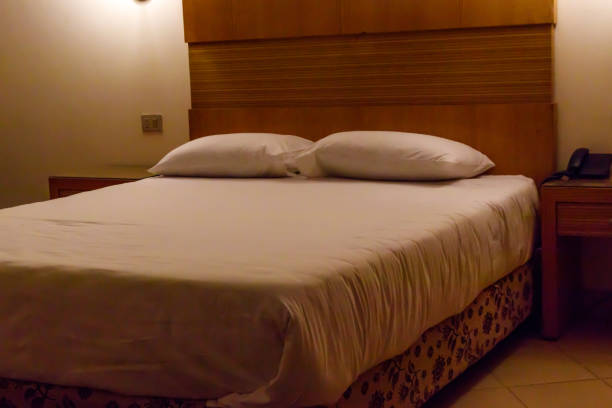 Double bed with two pillows in bedroom in soft lights