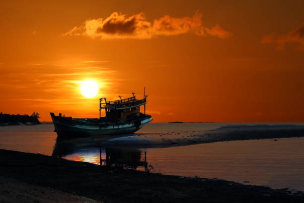 istock Old broken boat abandoned on the beach at sunset ,Red sky 1146606229