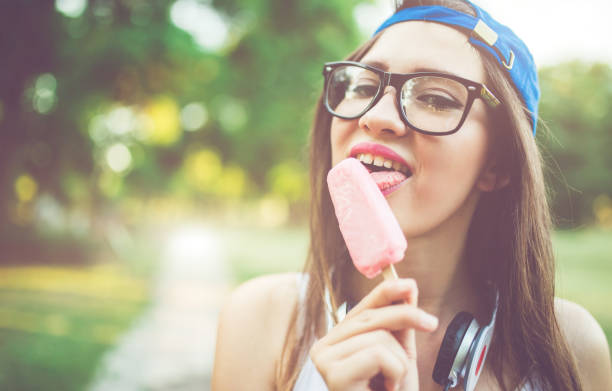 Pretty girl licking ice cream in a park