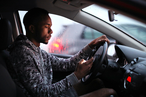 African man driving in the rain.