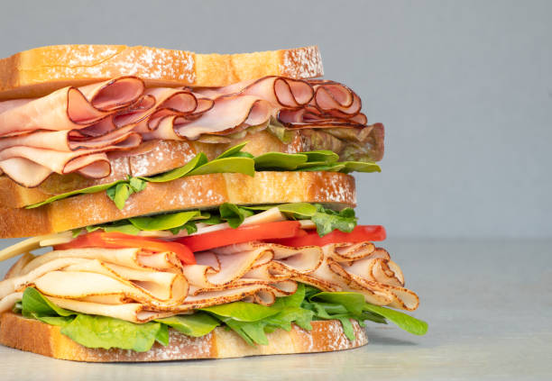 istock Fresh double layered sandwich with ham, lettuce, tomatoes, cheese on a toast bread. 1146609349