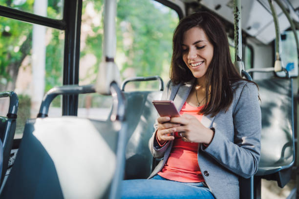 istock Young woman using phone on a city bus ride 1146610302