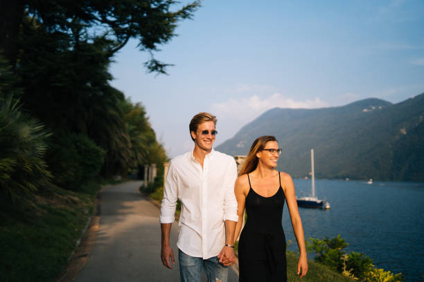 Couple walk along promenade at sunset