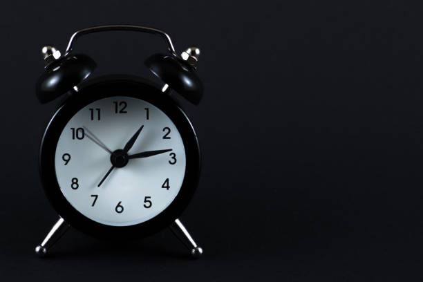 istock Black retro alarm clock on black background 1146618280