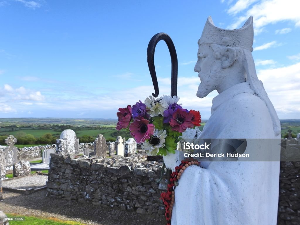 St Patrick St Patrick on the Hill of Slane with panoramic views of the Irish countryside in the background. Saint Patrick - Saint Stock Photo