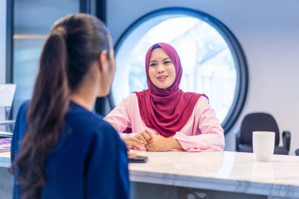 istock Young woman checking in at reception desk 1146618842