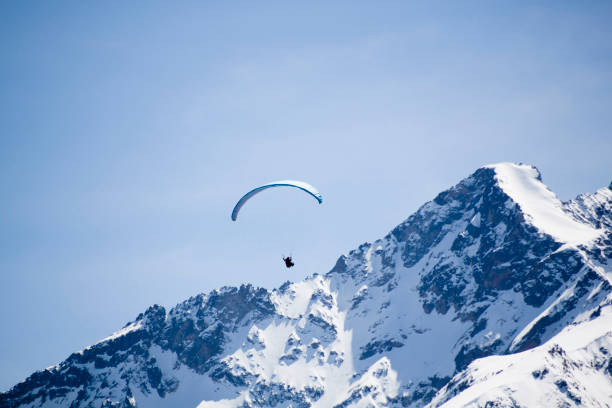 istock one blue parachute flying in the sky over a peak 1146621469
