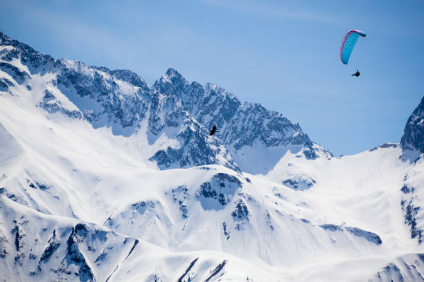 istock one blue parachute flying in the sky over a snowed mountain 1146621556
