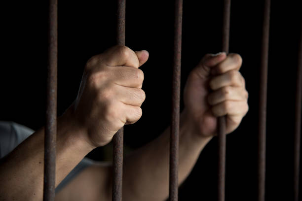 istock Close-Up Of Man Holding Prison Bars 1146627953