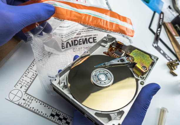 Police expert examines hard drive in search of evidence, conceptual image Police expert examines hard drive in search of evidence, conceptual image forensic science stock pictures, royalty-free photos & images