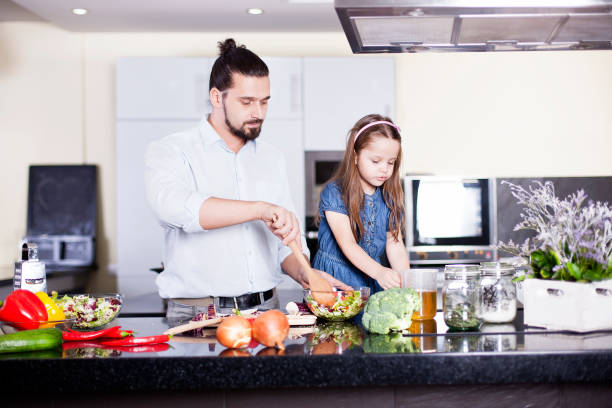 istock Father and daughter cooking meal together 1146629830