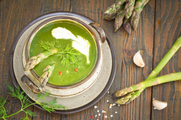 Green spring pureed asparagus soup in a bowl stock photo