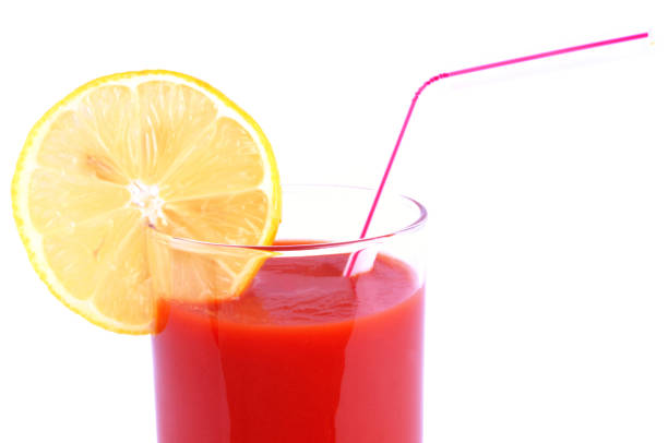 Close-up of a glass of tomato juice with a straw