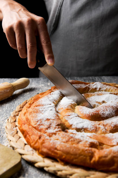 istock man cutting ensaimada typical of Mallorca, Spain 1146642328