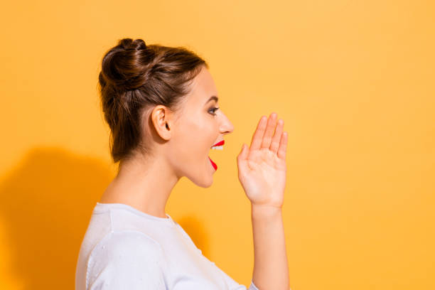 Profile side view close up photo of young attractive nice lady sharing incredible news about her life. She is raising her hand opening mouth isolated over vivid background in white clothes Profile side view close up photo of young attractive nice lady sharing incredible news about her life. She is raising her hand opening mouth isolated over vivid background in white clothes. topknot stock pictures, royalty-free photos & images