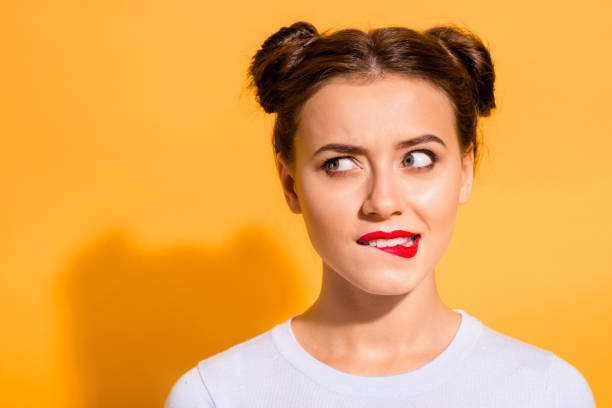 close-up portrait of her she nice attractive lovely winsome stunning glamorous funny wondered girl biting lip looking aside isolated over bright vivid shine yellow background - hair bun hairstyle beautiful looking imagens e fotografias de stock