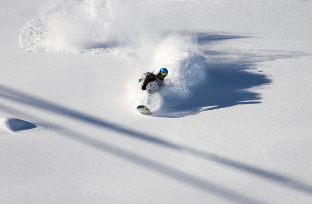 equitação do snowboarder na neve profunda do pó no dia de inverno frio e ensolarado - skiing winter sport powder snow athlete - fotografias e filmes do acervo