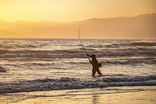Lonely fisherman surf casting