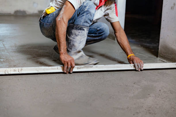 der bautechniker arbeitet daran, den betonboden zu ebnen, um glatt zu sein. - zementboden stock-fotos und bilder