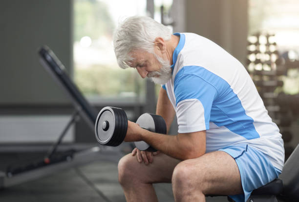 istock Fit elderly man working out with dumbbells in gym. 1146647479