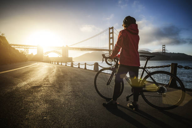 kobieta z rowerem wyścigowym i mostem golden gate - bridge road city golden gate bridge zdjęcia i obrazy z banku zdjęć