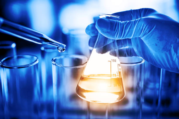 istock Flask in scientist hand with lab glassware background in laboratory. Science or chemical research and development concept. 1146649022