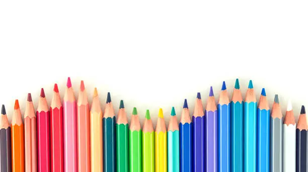 Photo of Closeup of coloured pencils lined up in a row on white background copy space