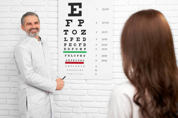 istock Doctor in white uniform standing near test eye chart. 1146652206