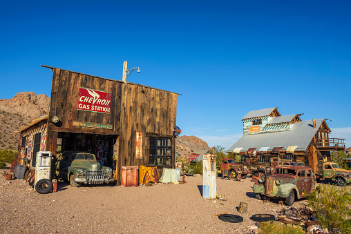 Nelson, Nevada, USA - October 23, 2018 : Old wooden houses, vintage fuel pumps and rusty car wrecks in Nelson ghost town located in the El Dorado Canyon and surrounded by Eldorado Mountains.
