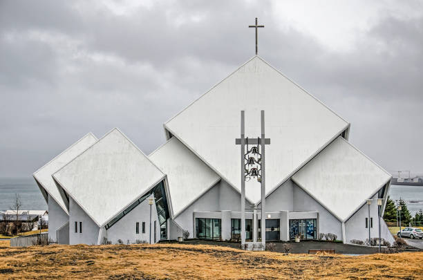 Reykajvik, Iceland, February 25, 2019: north facade of the sculptural church at the district of Seltjarnarness under a cloudy sky with the ocean in the background
