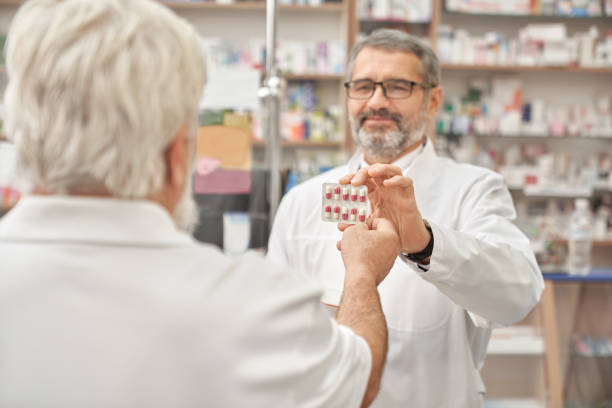 istock Pensioner taking blister pack from pharmacist. 1146665261