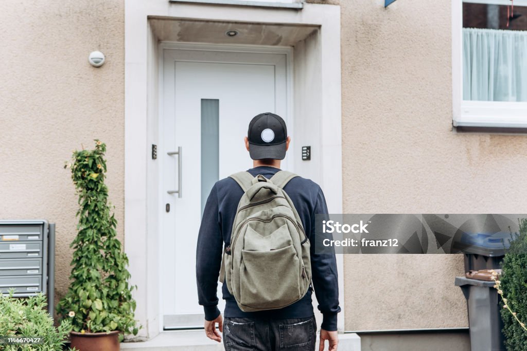 The tourist or the student with the backpack. A tourist goes to the guesthouse or hostel in order to stay in a room that he booked. Arrival Stock Photo