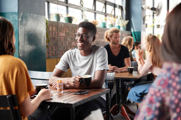 istock Couple Sitting At Table In Busy Coffee Shop Talking 1146671742